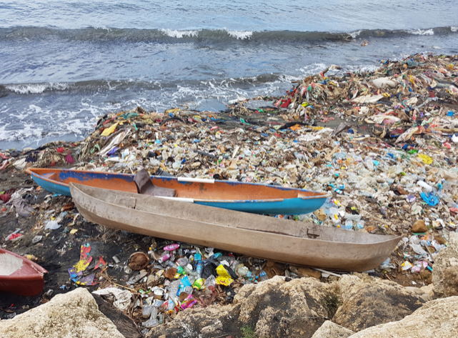 two boats on beach with lots of litter